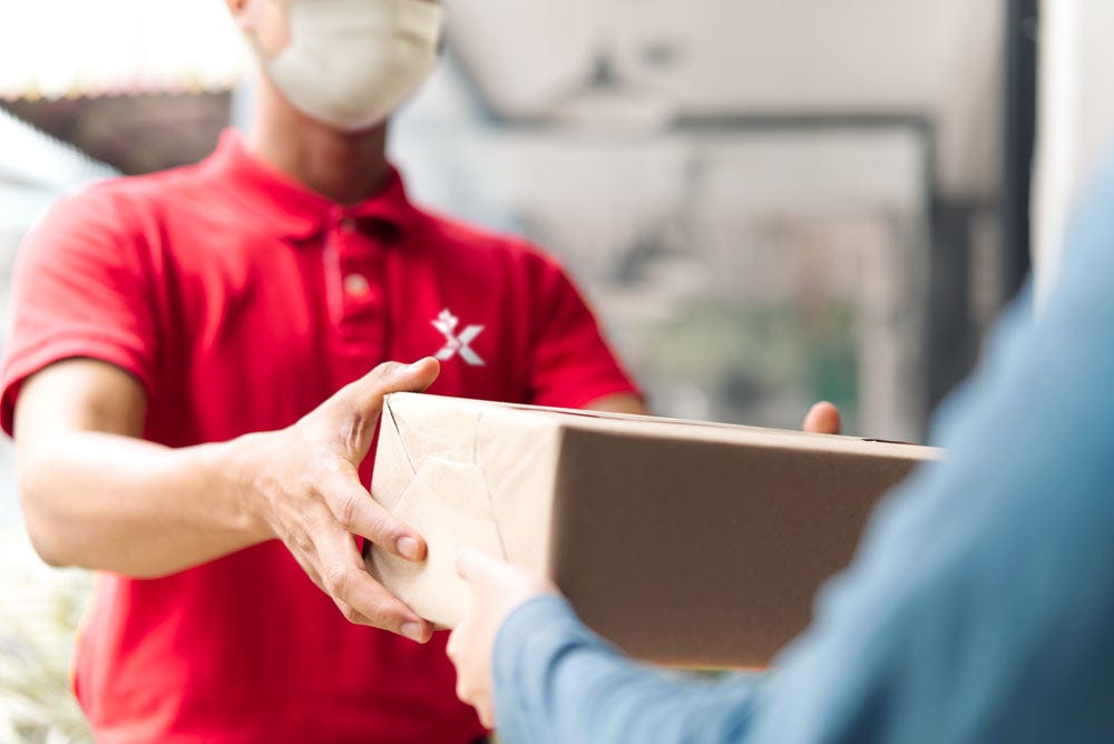 image of a canex worker handing parcel to the customer